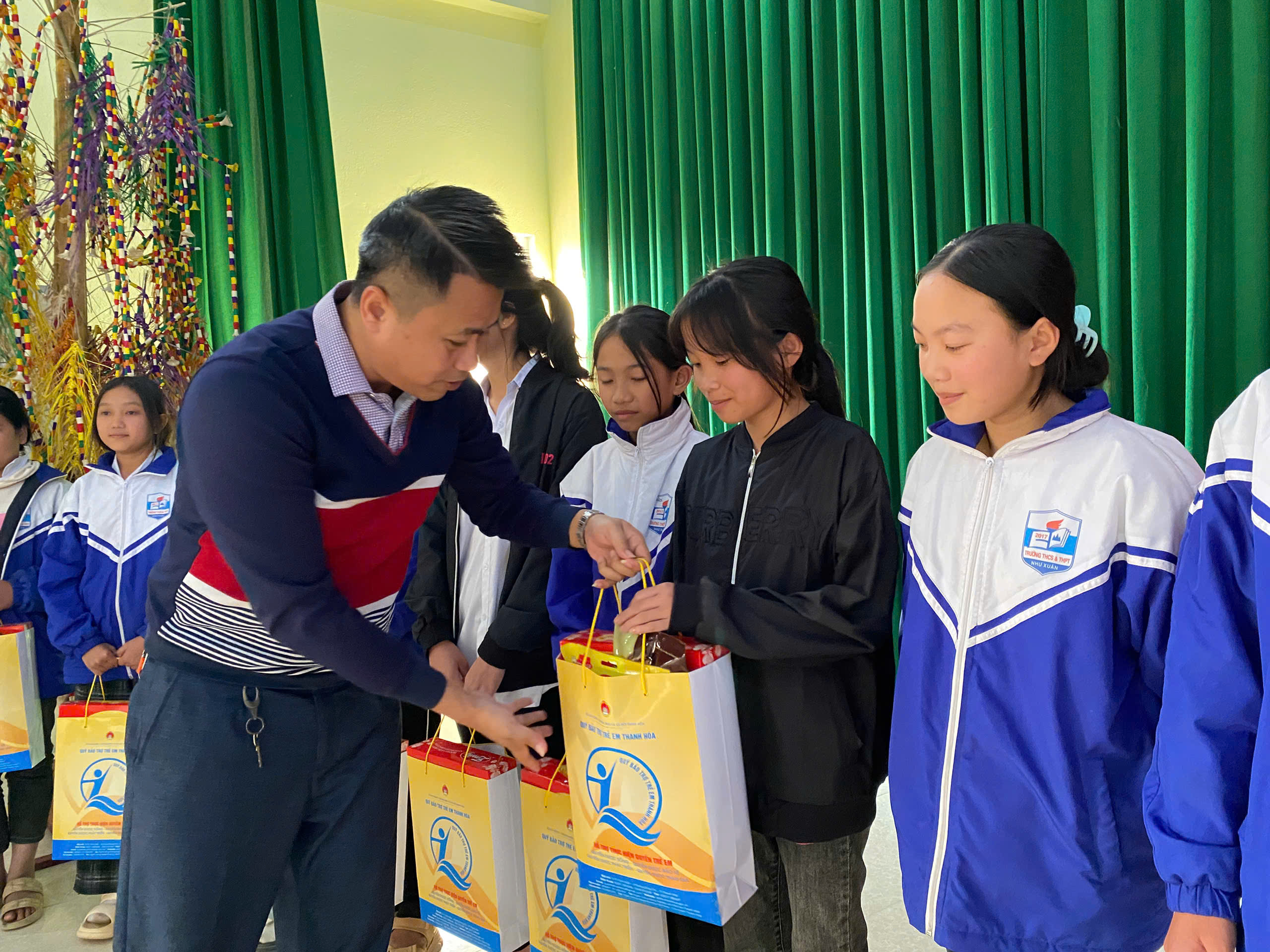 Đồng chí Lại Thế Quảng - Giám đốc Quỹ BTTE trao quà cho trẻ em Như Xuân.
