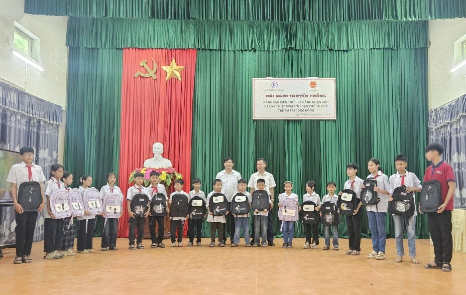 Lãnh đạo Trung tâm và lãnh đạo xã Nga Thắng trao balo cho trẻ em có hoàn cảnh khó khăn.