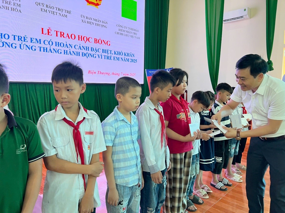 Ông Hoàng Duy Xuyên - Giám đốc Trung tâm trao học bổng cho các em học sinh
